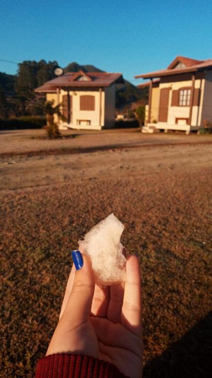 a person holding a piece of food in their hand at Pousada Landhaus in Urubici
