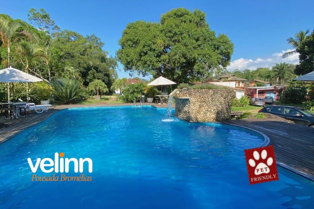 uma piscina numa villa com piscina e um resort em VELINN Pousada Bromelias em Ilhabela