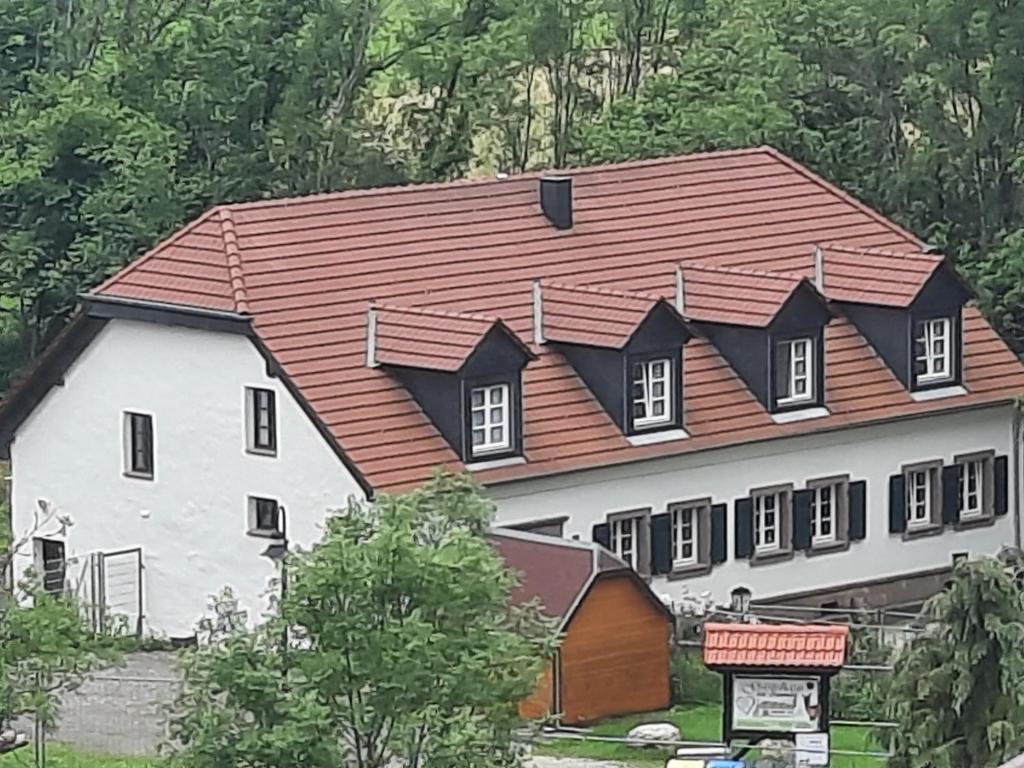 una gran casa blanca con techo rojo en Gästehaus Alte Klostermühle, en Gräfinthal