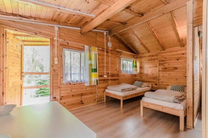 una camera con due letti in una cabina di legno di OW POLAM a Stegna