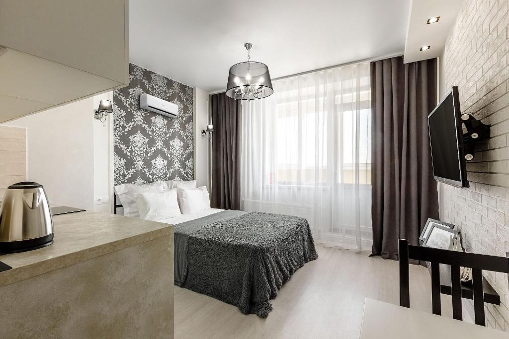 ケメロヴォにあるСтудио апартаменты Времена годаのベッドとデスクが備わるホテルルームです。