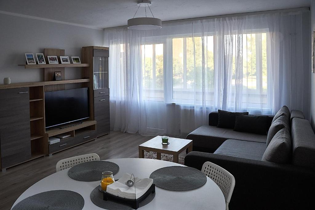 a living room with a couch and a table at Rundale Solstice Apartment in Pilsrundāle