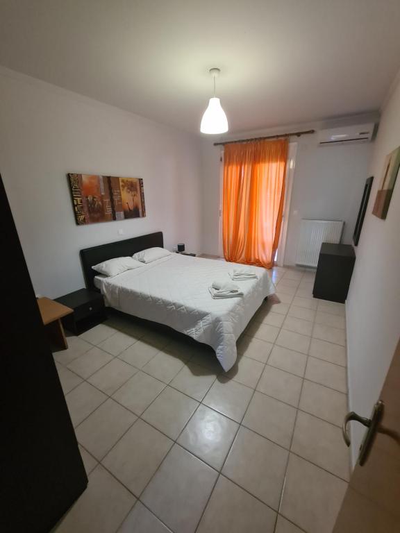 a bedroom with a bed and an orange curtain at Villa Valeria Thassos in Limenas