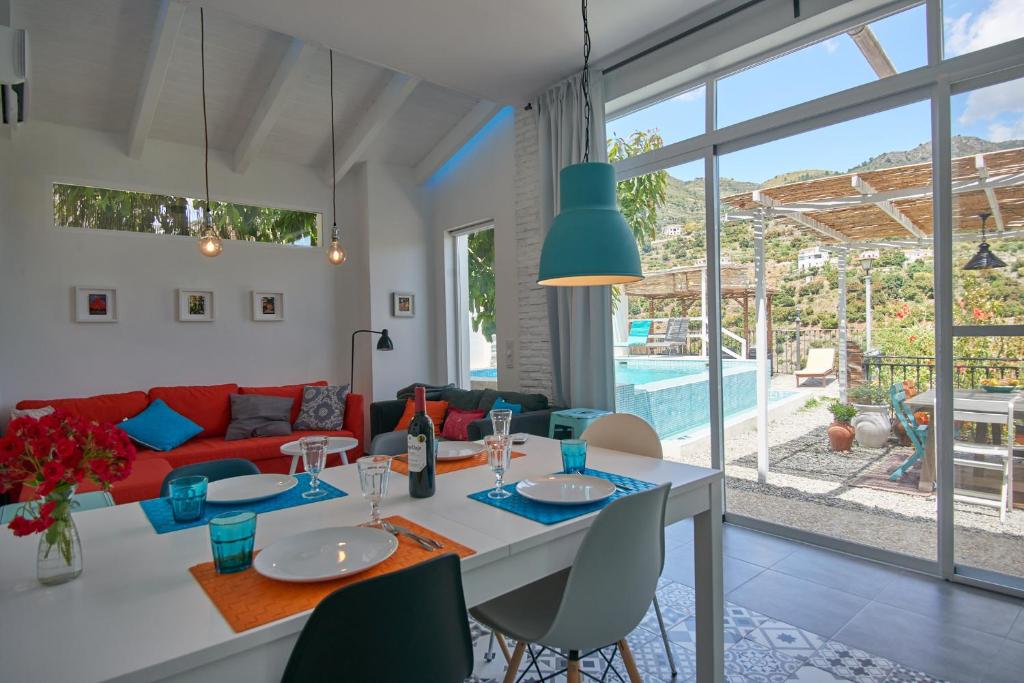 Il comprend une cuisine et un salon avec une table et des chaises. dans l'établissement Casa Turquesa 25 Minuten vom Strand, à Guájar Fondón