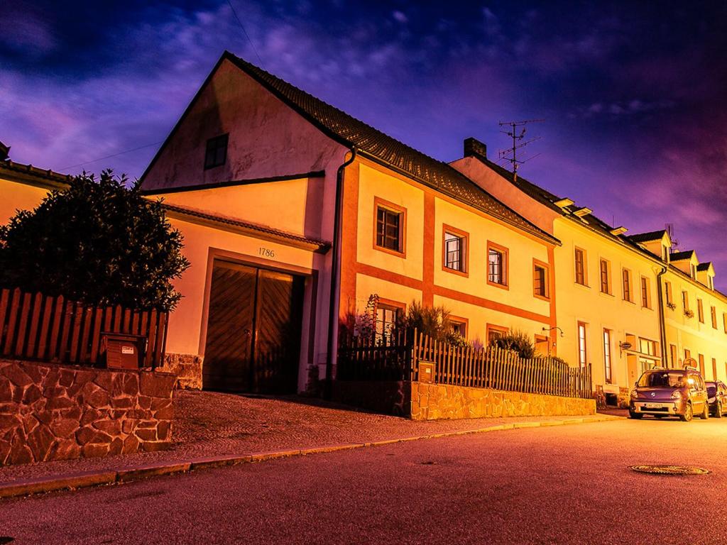 una gran casa blanca con una valla delante en Penzion 1670, en Nové Hrady