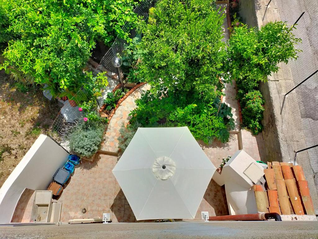 an overhead view of a white umbrella on a sidewalk at Casa Vacanze "Il Giardino" in Furnari