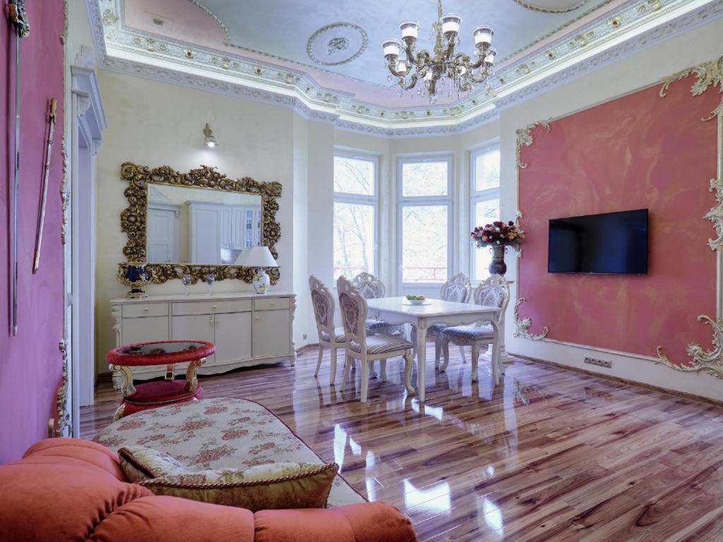 uma sala de estar com uma mesa e um espelho em Rose em Mariánské Lázně