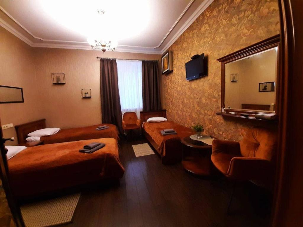 a hotel room with two beds and a mirror at Bogdanov Yar Hotel in Kyiv