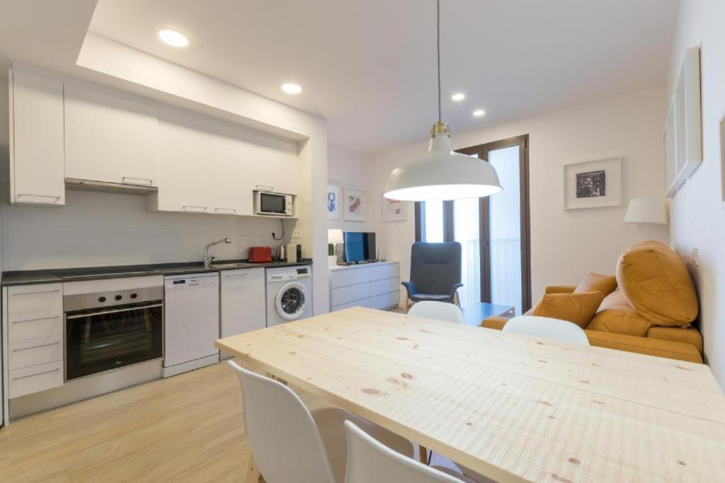 una cucina e un soggiorno con tavolo e sedie di Apartamentos Mercado Central a Valencia