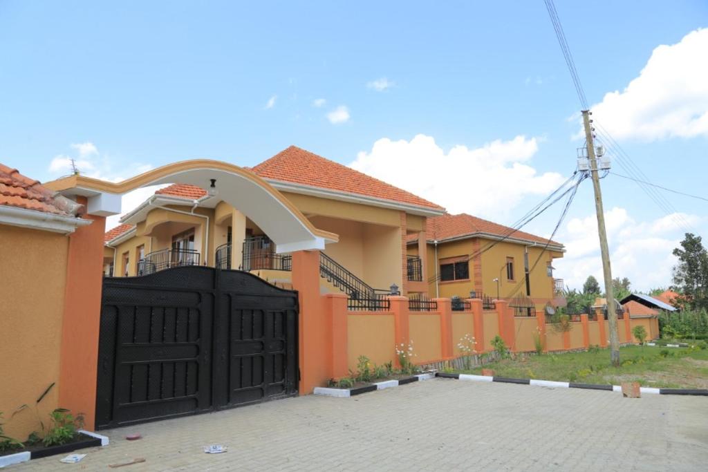 uma casa com um portão preto numa entrada em Legend Executive Suites em Fort Portal