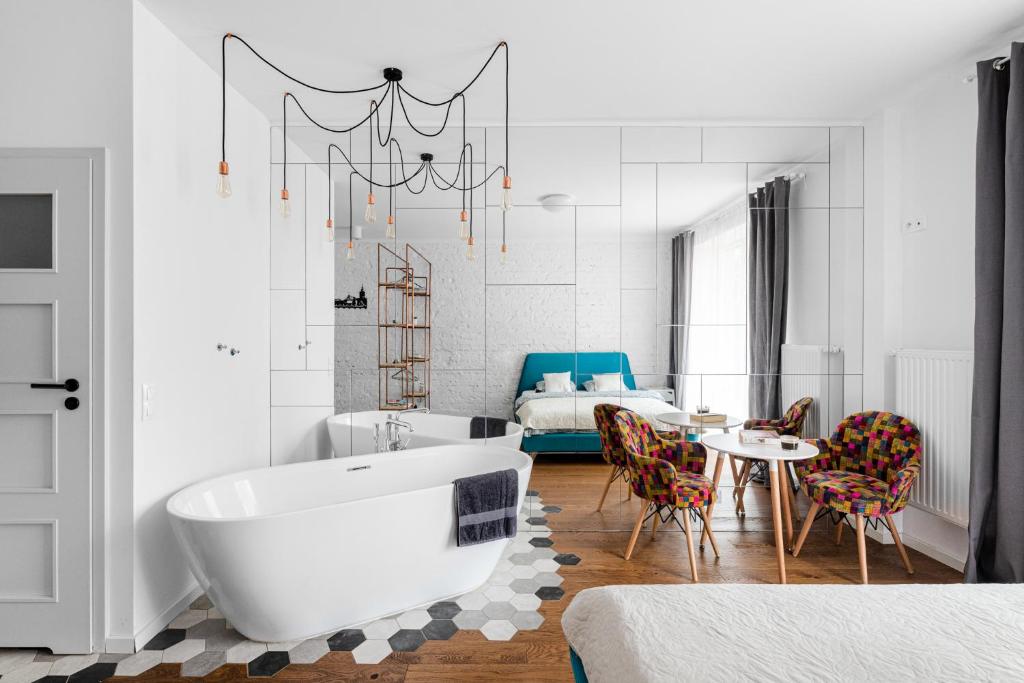 uma casa de banho com uma banheira, uma mesa e uma cama em Apartament Centrum- Nowy Świat em Varsóvia