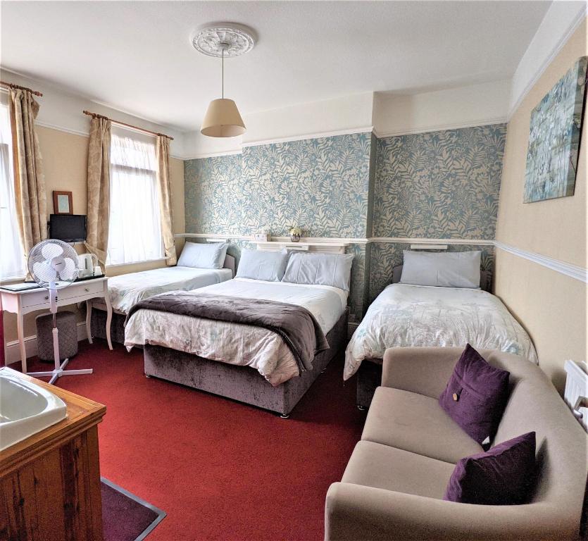 pokój hotelowy z 2 łóżkami i kanapą w obiekcie The Norman Guest House w mieście Dover