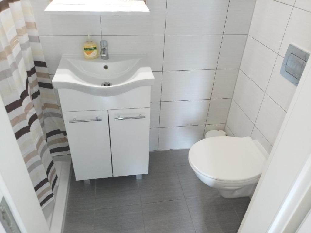 a bathroom with a white sink and a toilet at San Eleuterio Guesthouse in Poreč