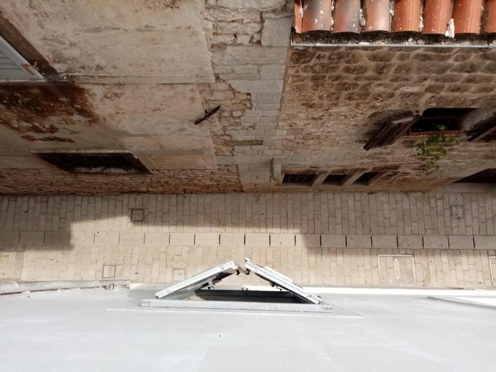 an empty room with a concrete ceiling and a wall at San Eleuterio Guesthouse in Poreč