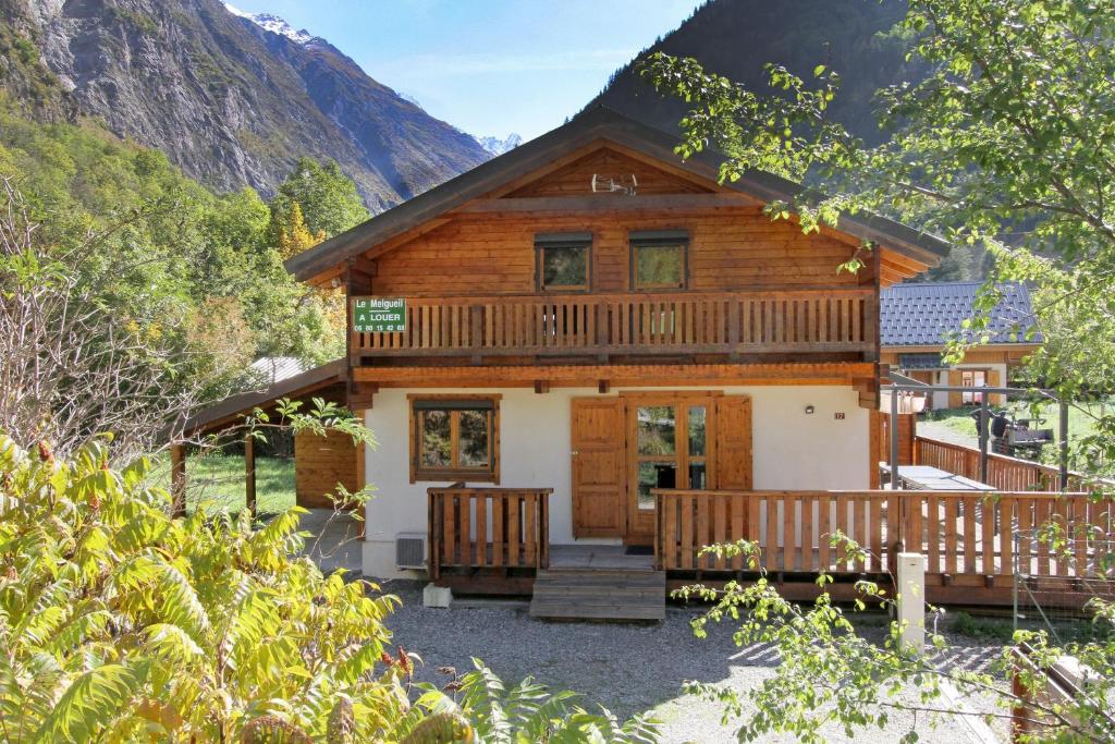 ヴェノスクにあるChalet de 5 chambres a Venosc a 400 m des pistes avec jacuzzi jardin clos et wifiの山々を背景にデッキが備わるログキャビン