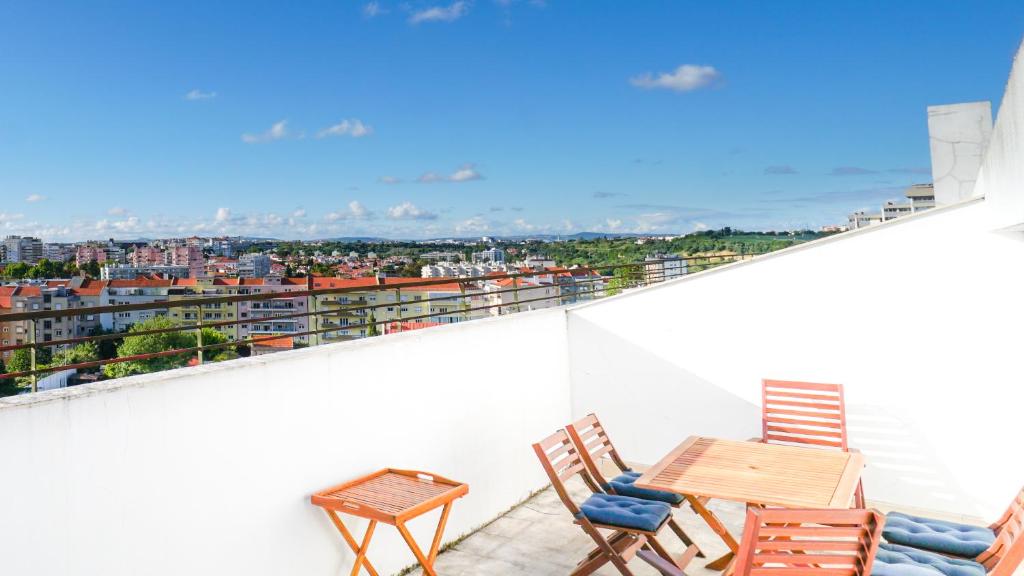 uma varanda com uma mesa e cadeiras e uma vista em Lisbon Best Places - Rooftop em Lisboa