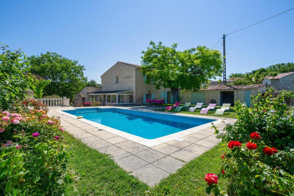 una piscina en el patio de una casa con flores en Villa de 3 chambres avec piscine privee jardin amenage et wifi a La Tour d'Aigues, en La Tour-dʼAigues