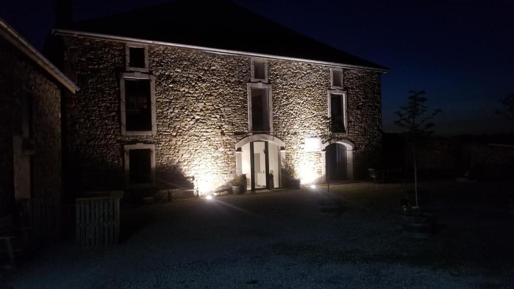 a brick building with lights on the front at night at CHAMBRES D'HOTES MANDACHAINA in Camou-Mixe-Suhast