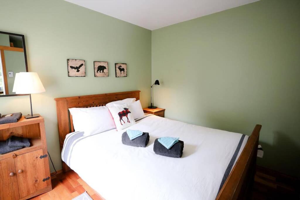 a bedroom with a large white bed with two pillows at The MountainSide by Escapades Tremblant in Mont-Tremblant