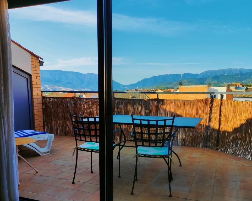 a patio with a table and chairs on a balcony at ACOGEDOR ÁTICO DÚPLEX EN TREMP in Tremp