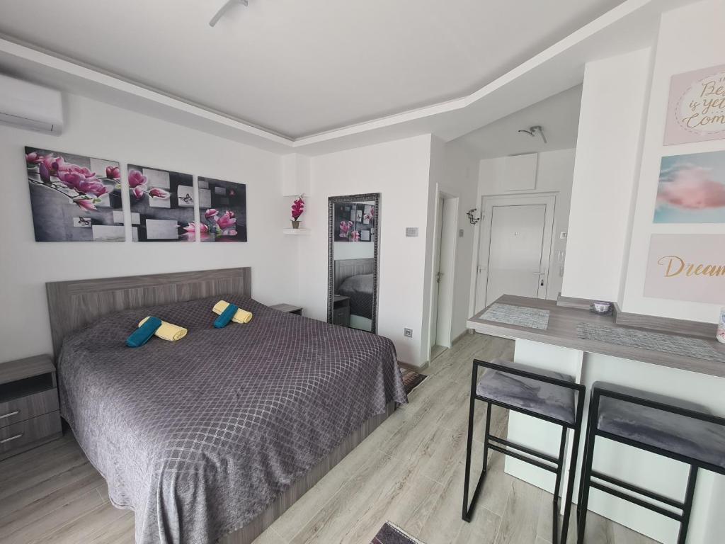 - une chambre avec un lit, une table et des chaises dans l'établissement Ema Apartman, à Bijeljina