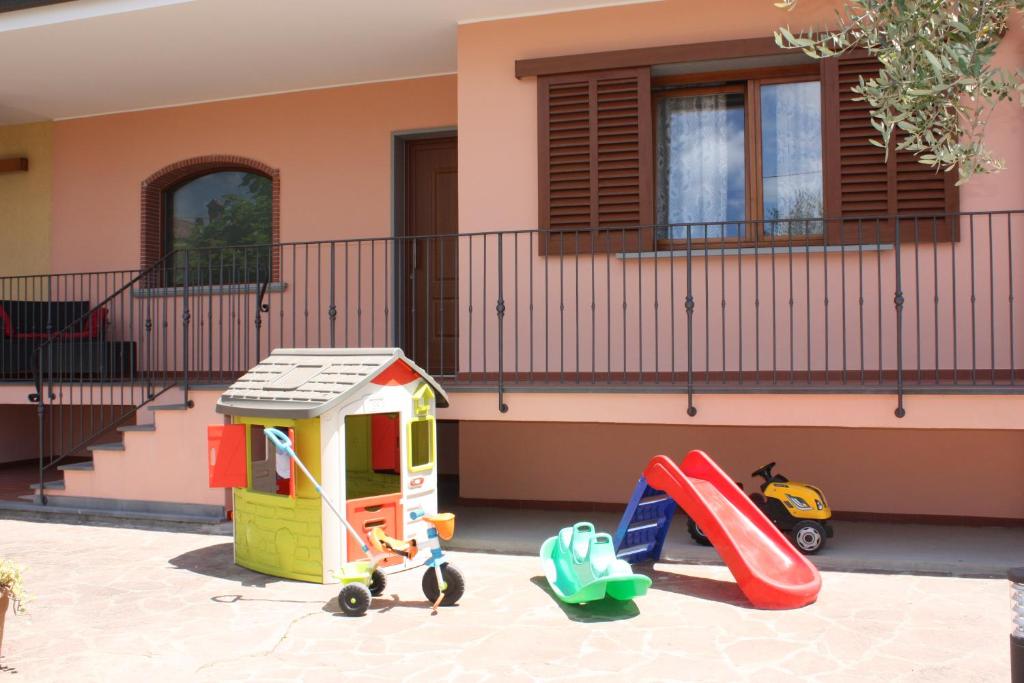 Tuscan Dream Casa Vacanze في بييفي أنييفولي: ملعب فيه زحليقة ومعدات لعب أمام المنزل
