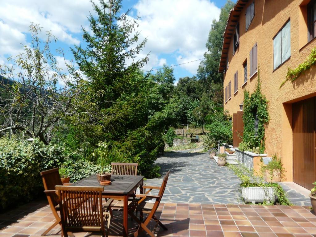 a patio with a table and chairs next to a building at Hostal l´Ou de Reig in Montseny