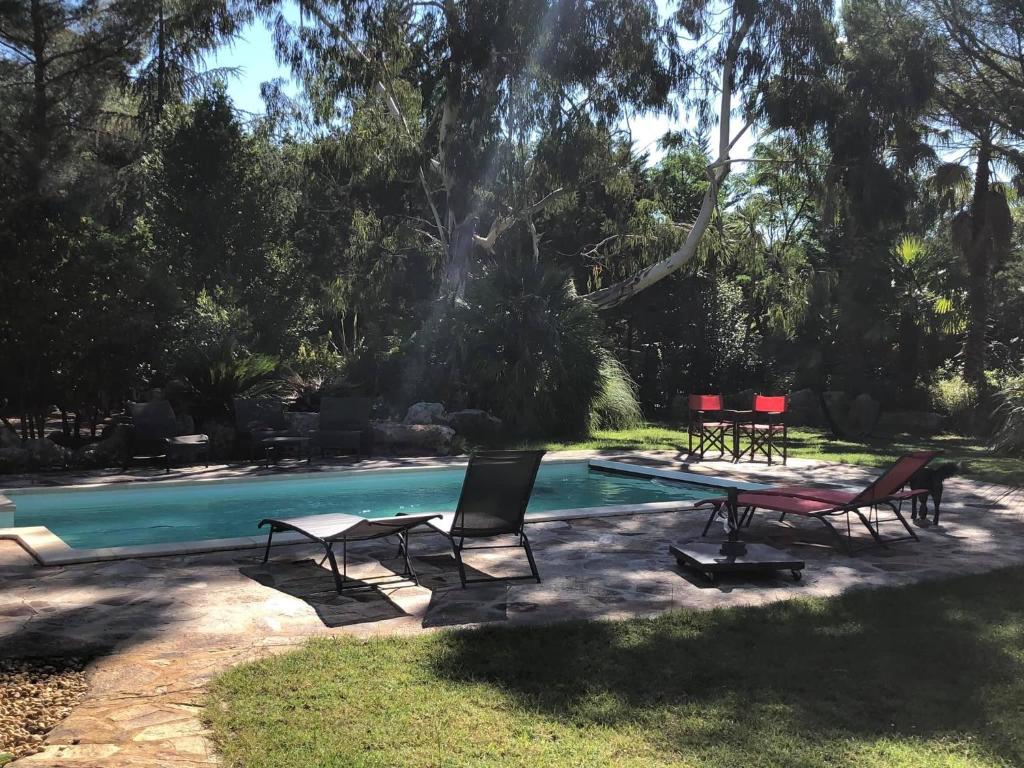 a pool with two chairs and a table next to it at Entre 2 rives. Entre 2 rêves in Thèzan-lès-Béziers