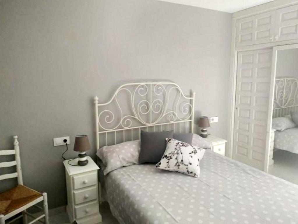 een slaapkamer met een wit bed met een kussen erop bij VikerBIESCAS in Biescas