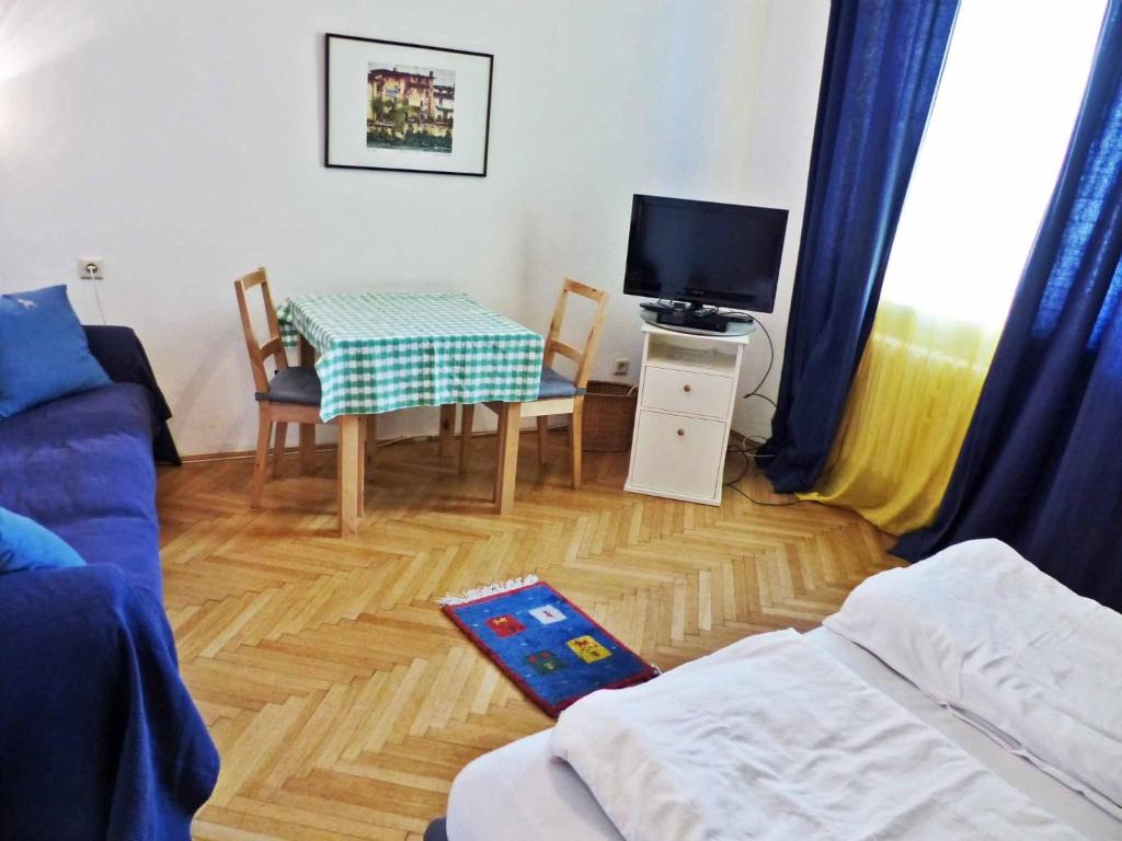 salon z kanapą, stołem i telewizorem w obiekcie Apartment Naschmarkt w Wiedniu