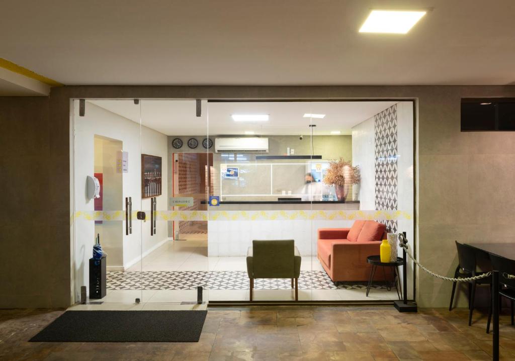 a living room with a sliding glass door with a couch at Hotel Vila Leste in Teresina