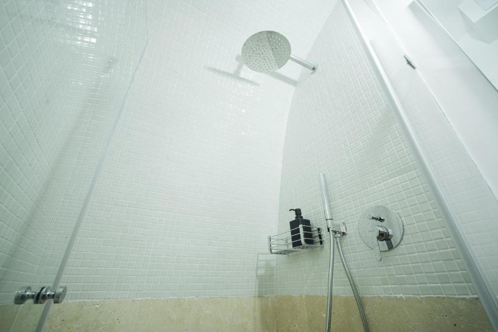 a bathroom with a shower with a sink and a mirror at חקל תפוחין in Safed