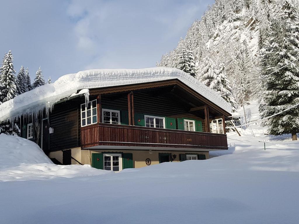 ein Blockhaus mit Schnee darüber in der Unterkunft Ferienhaus Erika in Mallnitz