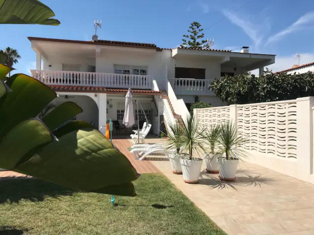 una casa con una valla y algunas plantas en el patio en Vivienda vacacional Josver en Benicàssim