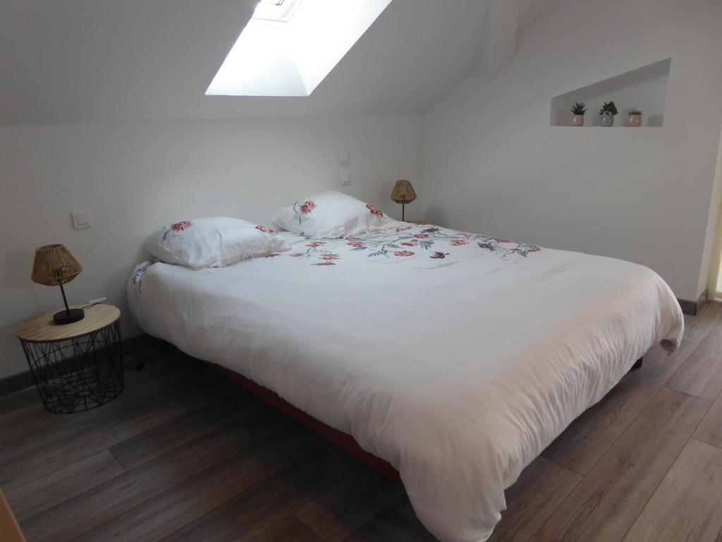 a bedroom with a large white bed with two pillows at Chez Brigitte et Gilbert in Guebwiller