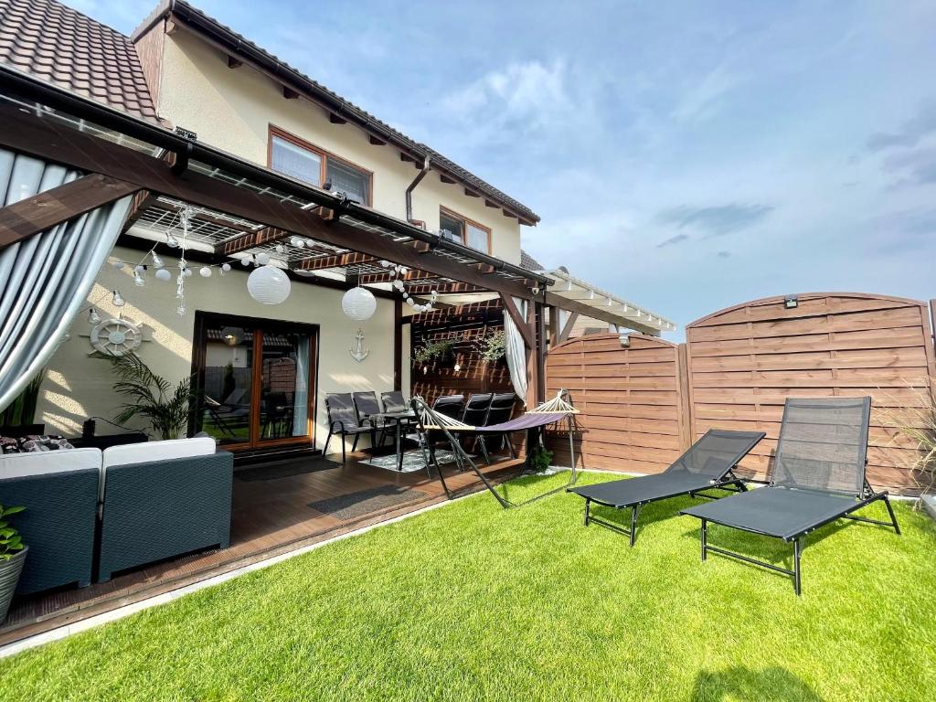 a backyard with a fence and chairs on the grass at Dom Dolores Pogorzelica in Pogorzelica