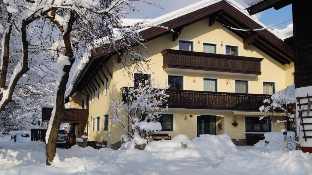 ein Haus mit Schnee auf dem Boden davor in der Unterkunft Haus Schön Weberhof in Kirchbichl