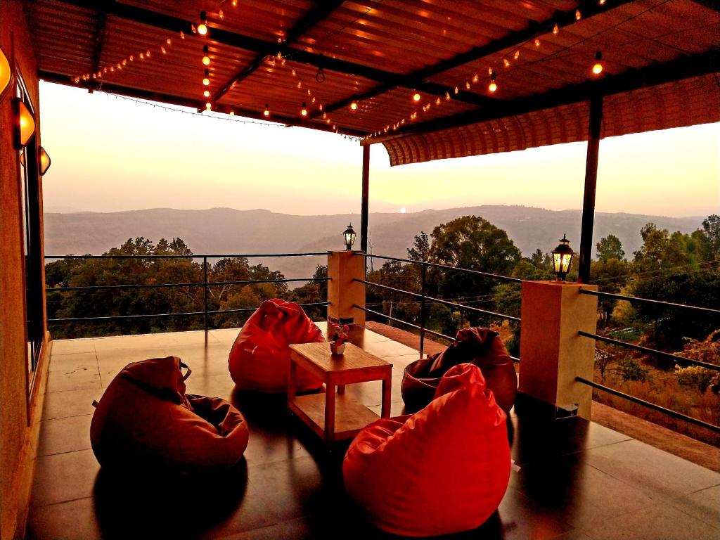 three people sitting in bean bags on a balcony with a view at Dadaji Villa in Panchgani