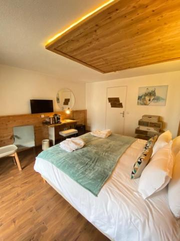 une chambre avec un grand lit avec un plafond en bois dans l'établissement Hotel SNOW CHILL, à Risoul