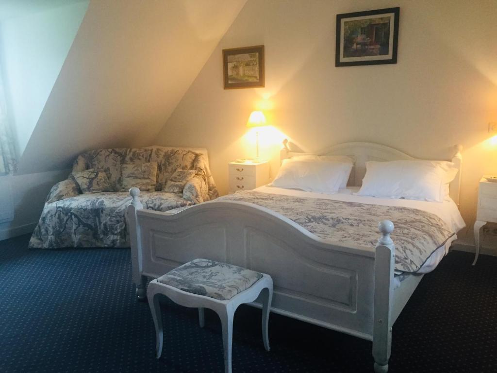 a bedroom with a white bed and a chair at LE CLOS DU GOLF in Dame-Marie-les-Bois