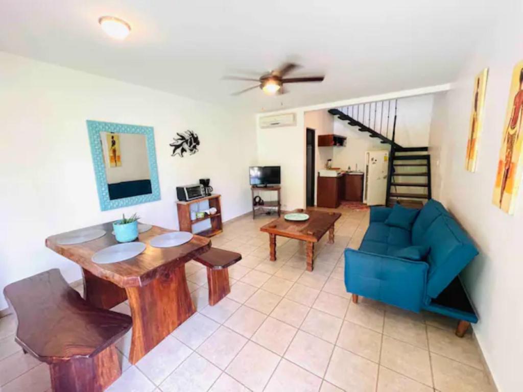 sala de estar con mesa y sofá azul en Mini Casa Cozy and Peaceful Beach Apartment, en Playa Grande