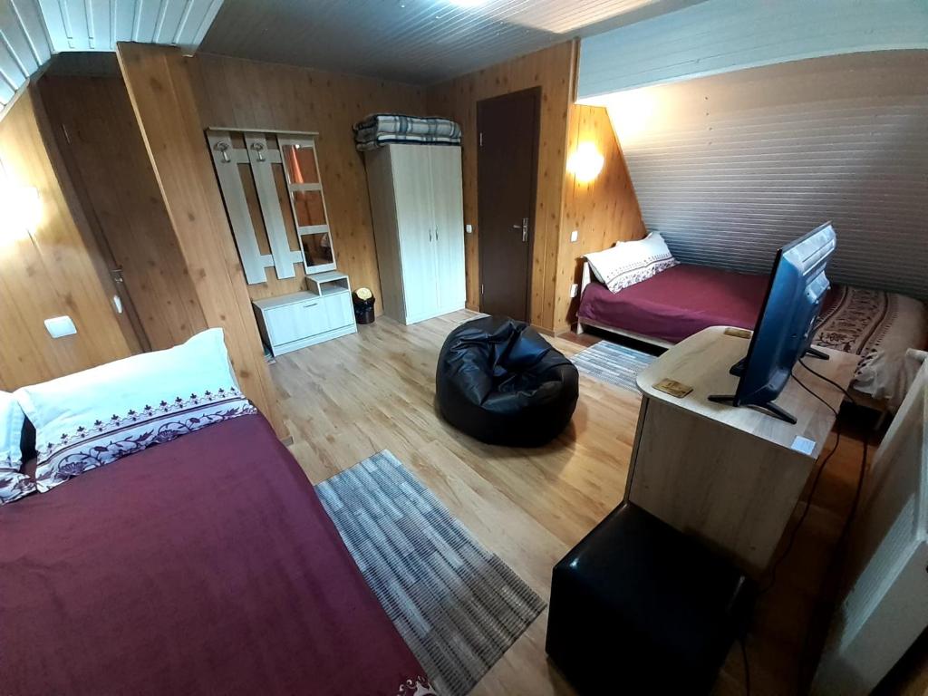 um quarto com uma cama e uma secretária com uma televisão em Casa Haiducilor em Predeal