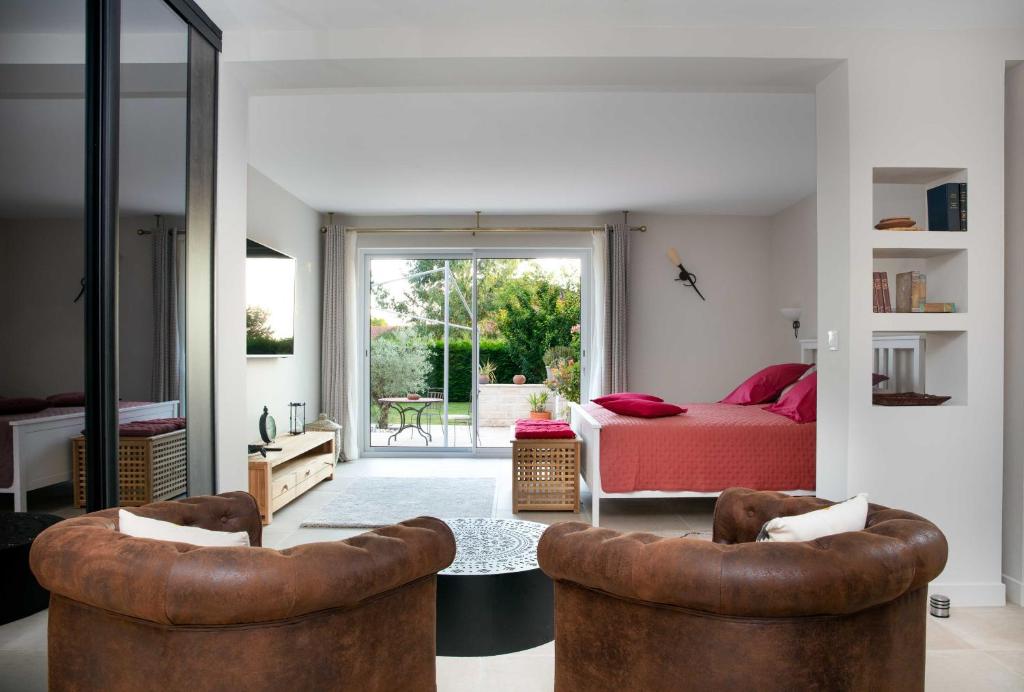 een woonkamer met 2 stoelen en een bed bij La perle rouge A Panazol in Panazol