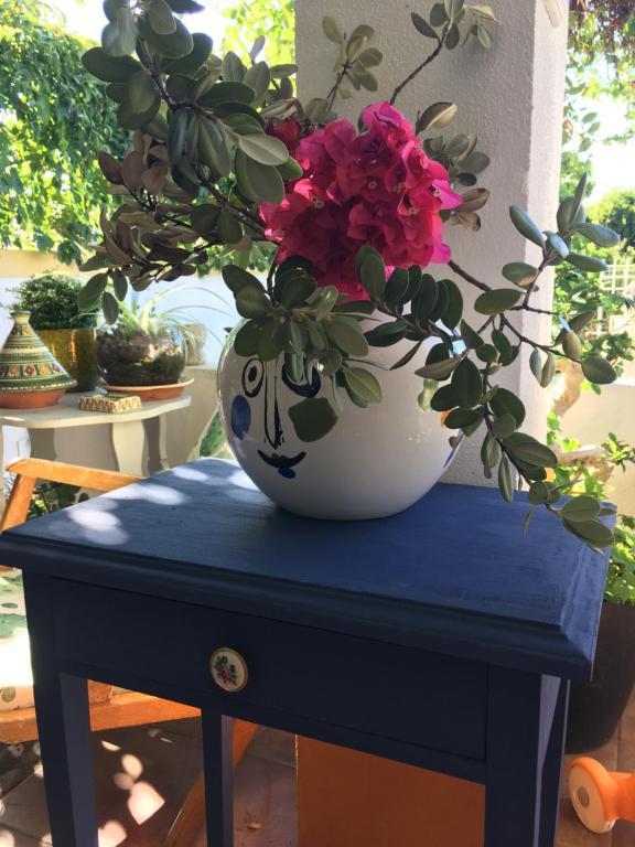 a blue table with a vase with flowers in it at A Casa do Lagar in Azeitao