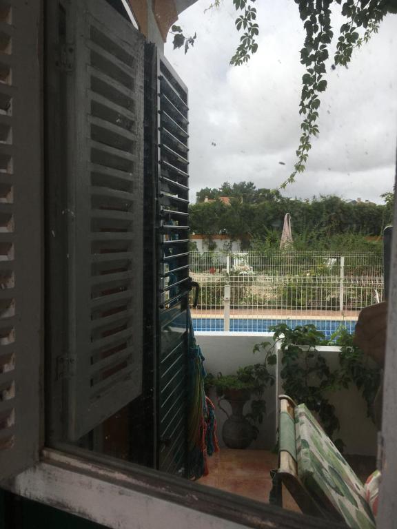 a window of a house with a view of a pool at A Casa do Lagar in Azeitao