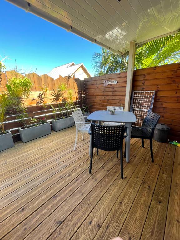 un patio con mesa y sillas en una terraza en Caze bois flotté, en Petite Île