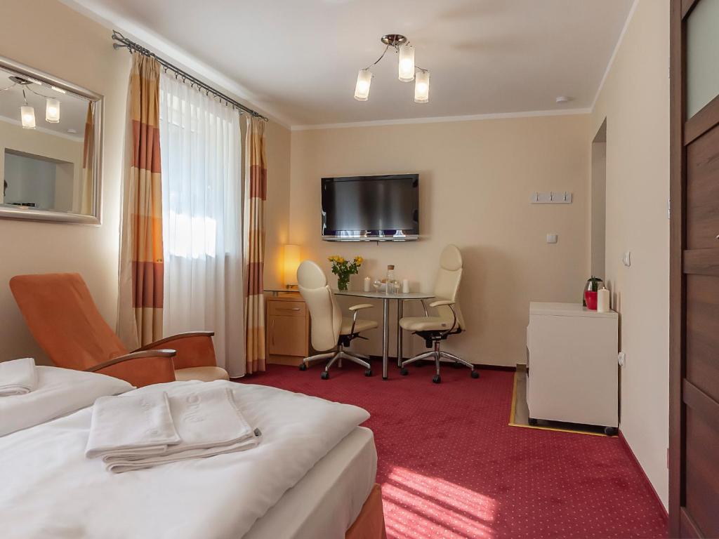 a hotel room with a bed and a table at VacationClub – 300 Mill Pokój 2 in Szklarska Poręba