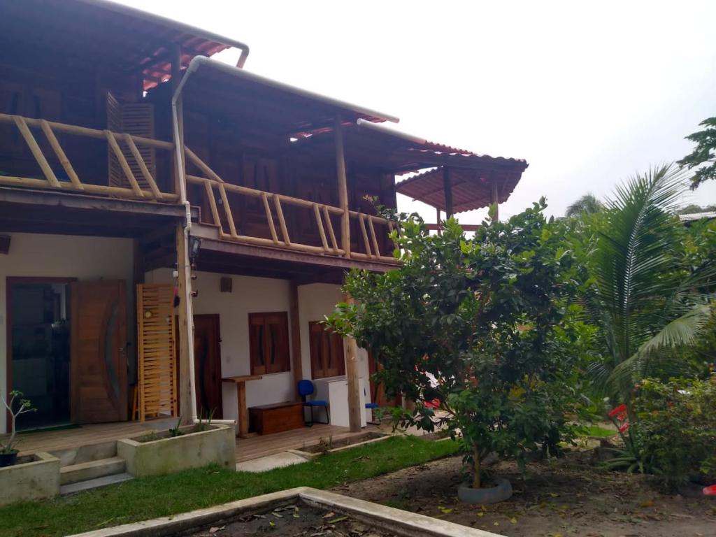 ein Haus mit einem Baum davor in der Unterkunft Hostel Amicum in Massarandupio