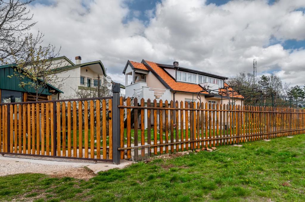 une clôture en bois devant une maison dans l'établissement Frile Apartments, à Nikšić