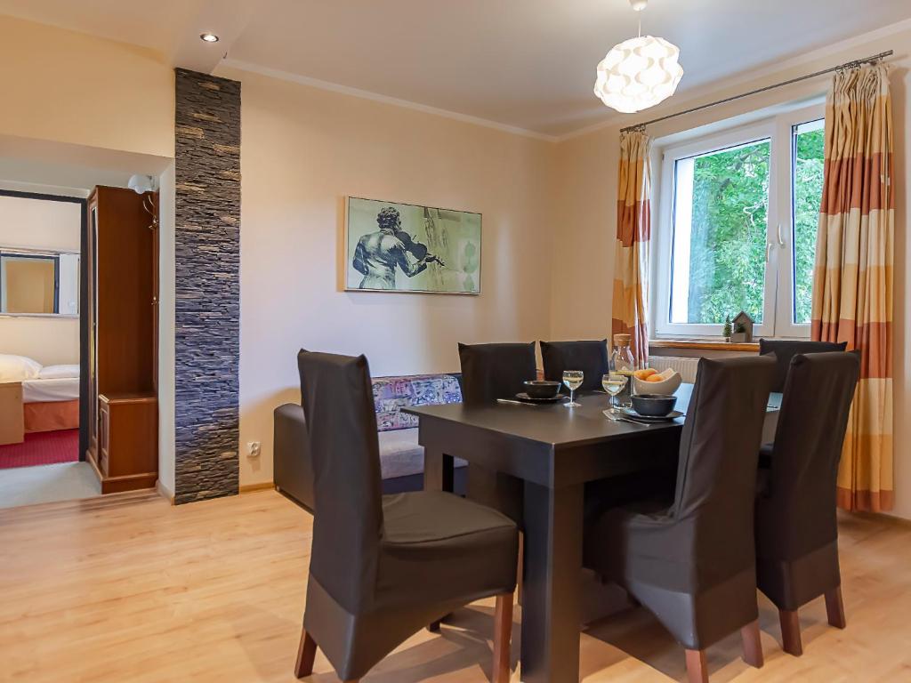 ein Esszimmer mit einem schwarzen Tisch und Stühlen in der Unterkunft VacationClub – 300 Mill Pokój 3 in Szklarska Poręba